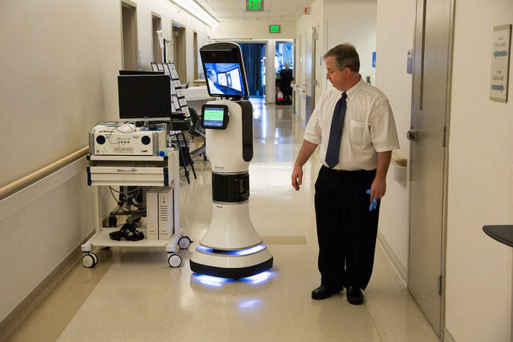 Traumatic Brain Injury Specialist Dr. Paul Vespa pictured with a care robot.
