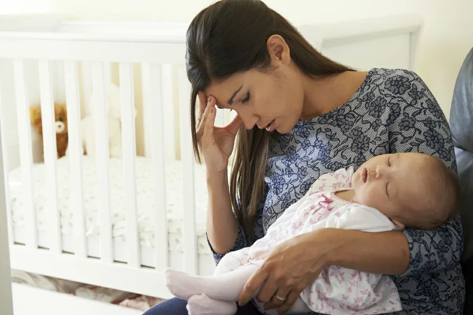 Mother struggling holding newborn baby depicting the common breastfeeding challenge of mastitis 